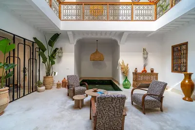 a living room with chairs and a table at Riad Sofia Marrakech in Marrakech