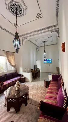 a living room with purple couches and a tv at charmant appartement Marrakech in Marrakech