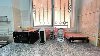 a kitchen with a microwave and appliances on the floor at charmant appartement Marrakech in Marrakech