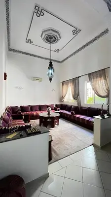 a living room with purple couches and a table at charmant appartement Marrakech in Marrakech