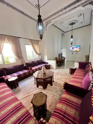 a living room with purple couches and a table at charmant appartement Marrakech in Marrakech