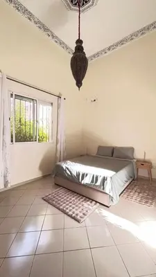 a bedroom with a bed and a chandelier at charmant appartement Marrakech in Marrakech