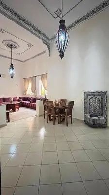a living room with a table and chairs and a couch at charmant appartement Marrakech in Marrakech