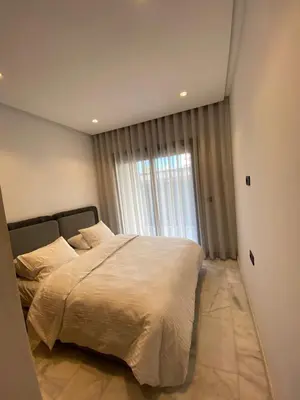 a bedroom with a large bed and a window at Chambre privée dans un appartement bien équipé in Marrakech