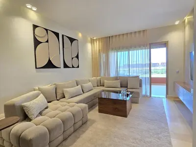 a living room with a couch and a tv at Sublime Apartment at Prestigia Golf, Marrakech in Marrakech