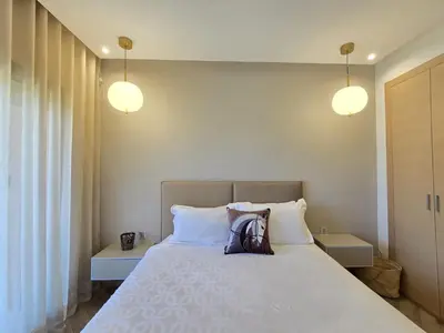 a bedroom with a bed with two pillows and two lights at Sublime Apartment at Prestigia Golf, Marrakech in Marrakech