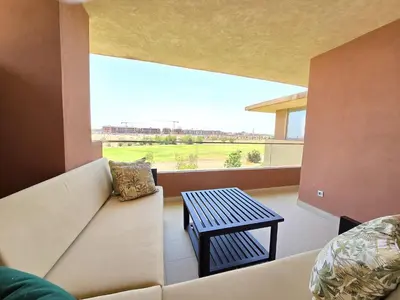 a living room with a couch and a table at Sublime Apartment at Prestigia Golf, Marrakech in Marrakech