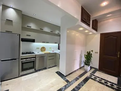 a kitchen with a refrigerator and a stove top oven at Warda 2 Bedroom Hivernage Apartment in Marrakech