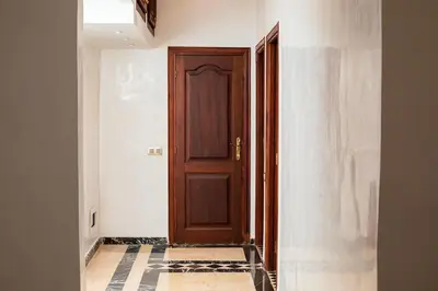 a hallway with a wooden door and a tile floor at Warda 2 Bedroom Hivernage Apartment in Marrakech