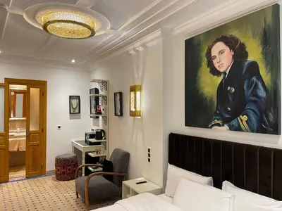 a bedroom with a painting of a woman on the wall at Riad Casa Maria in Marrakech