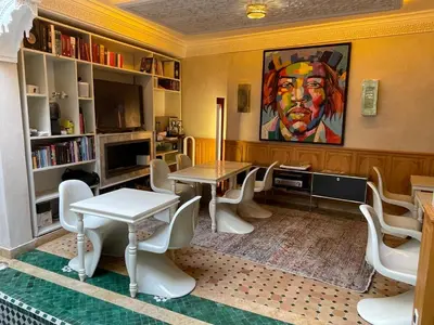 a room with a table and chairs and a painting at Riad Casa Maria in Marrakech
