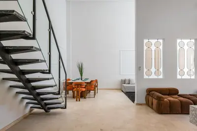 a staircase in a living room with a table and chairs at Duplex 5 Chambres à Marrakech Luxe, Vue Piscine in Marrakech