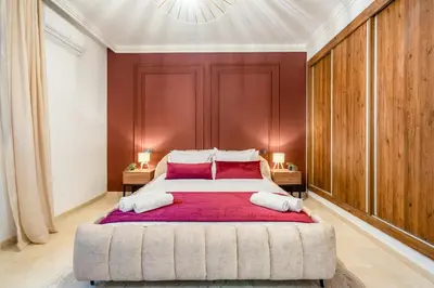 a bedroom with a large bed with red pillows at Duplex 5 Chambres à Marrakech Luxe, Vue Piscine in Marrakech