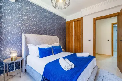 a bedroom with a bed with blue and white sheets at Duplex 5 Chambres à Marrakech Luxe, Vue Piscine in Marrakech