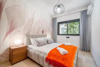 a bedroom with a bed with an orange blanket at Duplex 5 Chambres à Marrakech Luxe, Vue Piscine in Marrakech