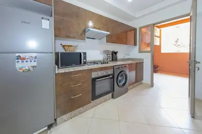 a kitchen with a refrigerator and a microwave at Luxueux Appartement Avec piscine in Marrakech