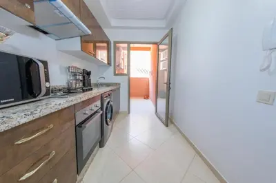 a kitchen with a sink and a stove at Luxueux Appartement Avec piscine in Marrakech