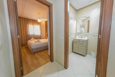 a bedroom with a bed and a bathroom with a sink at Luxueux Appartement Avec piscine in Marrakech