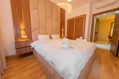 a bedroom with a large white bed in a room at Luxueux Appartement Avec piscine in Marrakech