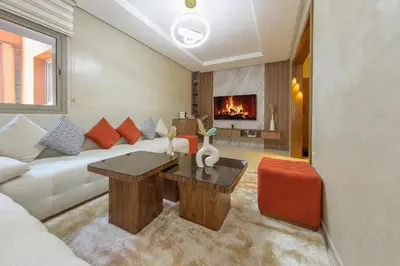 a living room with a white couch and a fireplace at Luxueux Appartement Avec piscine in Marrakech