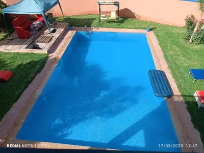 a large blue swimming pool in a yard at villa paradisiaque in Marrakech