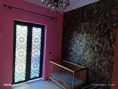 a pink room with a window and a crib at villa paradisiaque in Marrakech