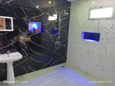 a bathroom with a sink and a tv on the wall at villa paradisiaque in Marrakech