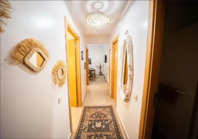 a hallway of a home with white walls and a carpet at Gate 3 in Marrakech