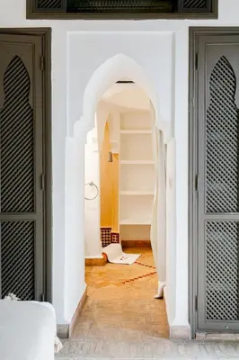 an archway in a white walled room with a door at Riad LOU, 5 bedrooms, private 12 p, pool, hammam in Marrakech