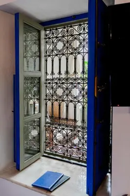 an open door with a gate and a book at Riad LOU, 5 bedrooms, private 12 p, pool, hammam in Marrakech