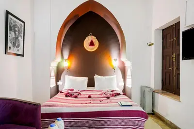 a bedroom with a large bed with an arch above it at Riad LOU, 5 bedrooms, private 12 p, pool, hammam in Marrakech