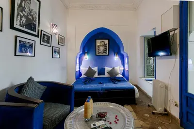 a bedroom with a blue bed and a table at Riad LOU, 5 bedrooms, private 12 p, pool, hammam in Marrakech
