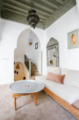 a living room with a white couch and a table at Riad LOU, 5 bedrooms, private 12 p, pool, hammam in Marrakech