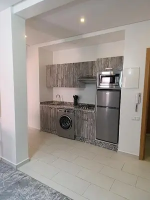 a kitchen with a stove and a washer and dryer at Magnifique studio douillet in Marrakech