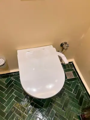 a white toilet in a bathroom with green tiles at Riad Appart F3 Exceptionnel à Guéliz - À 5 min de la gare - Piscine, Wi-Fi et parking au cœur de Marrakech in Marrakech