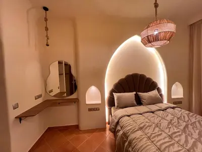 a bedroom with a bed and a mirror in a room at Riad Appart F3 Exceptionnel à Guéliz - À 5 min de la gare - Piscine, Wi-Fi et parking au cœur de Marrakech in Marrakech