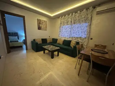 a living room with a green couch and a table at Nor in Marrakech