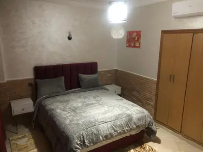 a small bedroom with a bed and a cabinet at Résidence Babylone Y - Appartement 2 Chambres in Marrakech