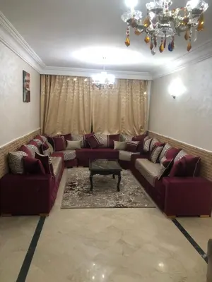 a living room with red couches and a chandelier at Résidence Babylone Y - Appartement 2 Chambres in Marrakech
