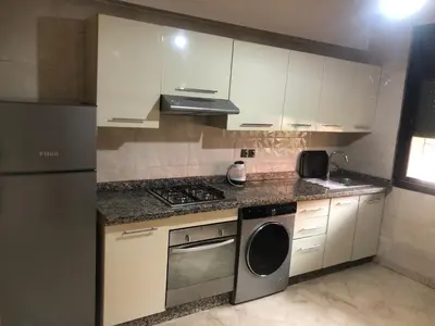 a kitchen with white cabinets and a stove and a dishwasher at Résidence Babylone Y - Appartement 2 Chambres in Marrakech