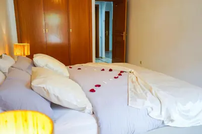 a white bed with red rose petals on it at Plaza Julianah in Marrakech