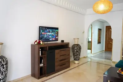 a living room with a television on a wooden entertainment center at Plaza Julianah in Marrakech
