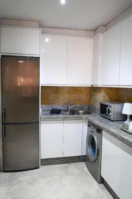 a kitchen with white cabinets and a stainless steel refrigerator at Plaza Julianah in Marrakech