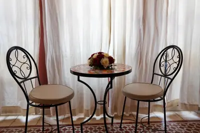 a table with two chairs and a table with flowers on it at Plaza Julianah in Marrakech