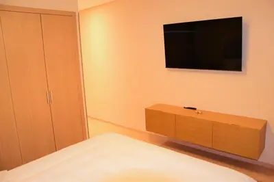 a bedroom with a dresser and a television on the wall at Apartement in Marrakech Village Prestigia - 2 Bedrooms - private pool in Marrakech