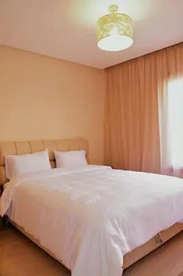 a bedroom with a large white bed with a window at Apartement in Marrakech Village Prestigia - 2 Bedrooms - private pool in Marrakech