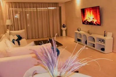 a living room with a white couch and a fireplace at Apartement in Marrakech Village Prestigia - 2 Bedrooms - private pool in Marrakech