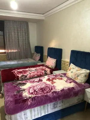 two beds in a room with purple sheets at - Résidence Babylone Y - 3 Bedrooms Appartement in Marrakech