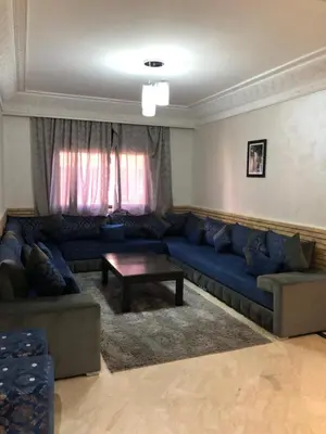 a living room with a blue couch and a table at - Résidence Babylone Y - 3 Bedrooms Appartement in Marrakech