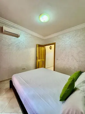 a bedroom with a large white bed in a room at spacieux appart familial avec 2 chambres in Marrakech